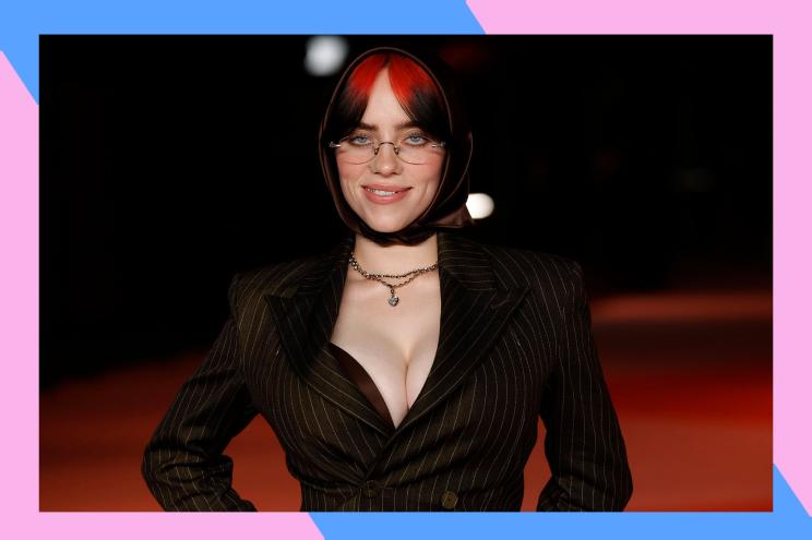 Billie Eilish flashes a devilish grin on the red carpet.