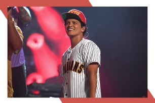 Bruno Mars smiles onstage.