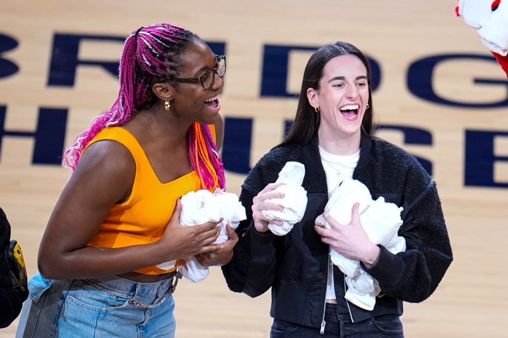 Indiana Fever players Aliyah Boston, left, and Caitlin Clark throw tee-shirts to fans during a time out during the first half between the Indiana Pacers and the Milwaukee Bucks in Game 2 in an NBA basketball first-round playoff series