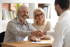 An older couple talks to a loan officer.