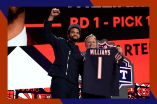 Chicago Bears quarterback Caleb Williams (L) raises his fist next to NFL Commissioner Roger Goodell after being selected with the number one pick at the 2024 NFL Draft.