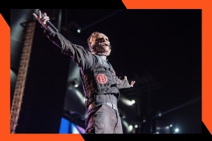 Masked Slipknot frontman Corey Taylor engages the crowd from the stage.