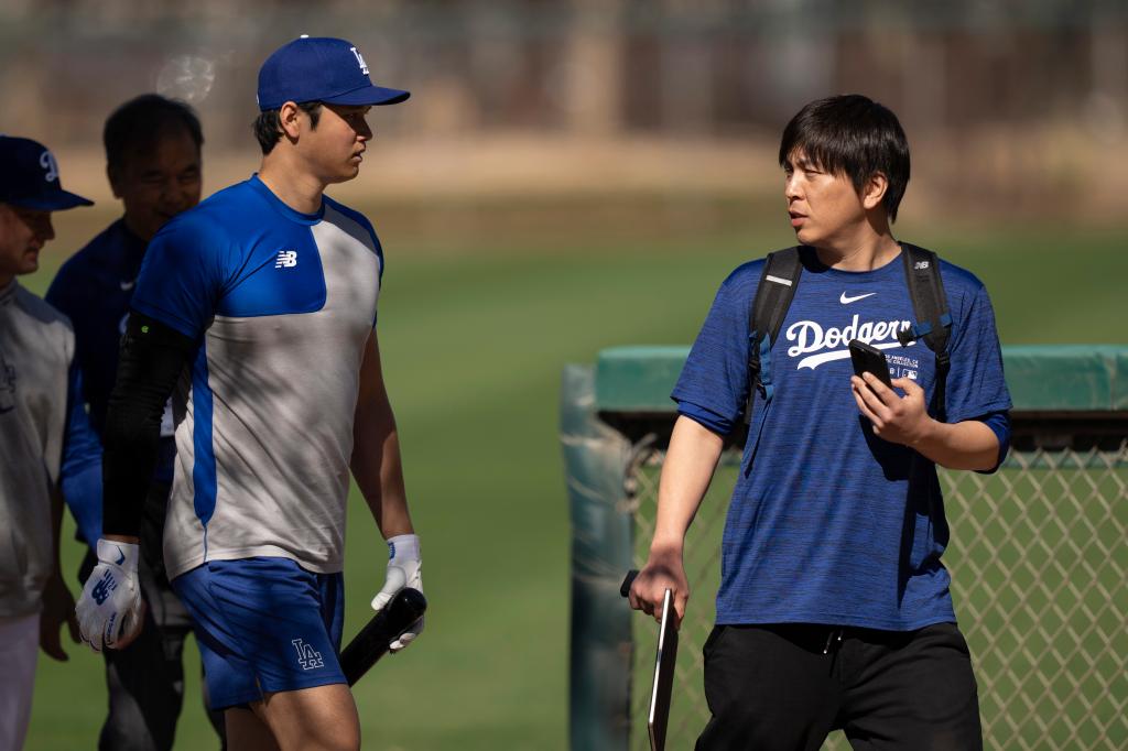 Los Angeles Dodgers' Shohei Ohtani walks with interpreter Ippei Mizuhara at batting practice during spring training baseball workouts in Phoenix on Feb. 12, 2024. Mizuhara has been fired by the Dodgers following allegations of illegal gambling and theft
