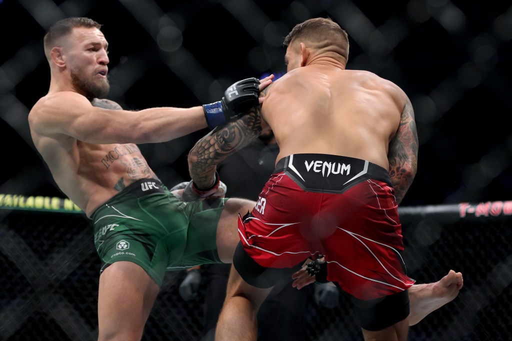 Conor McGregor of Ireland (L) attempts a kick against Dustin Poirier in the first round in their lightweight bout during UFC 264.