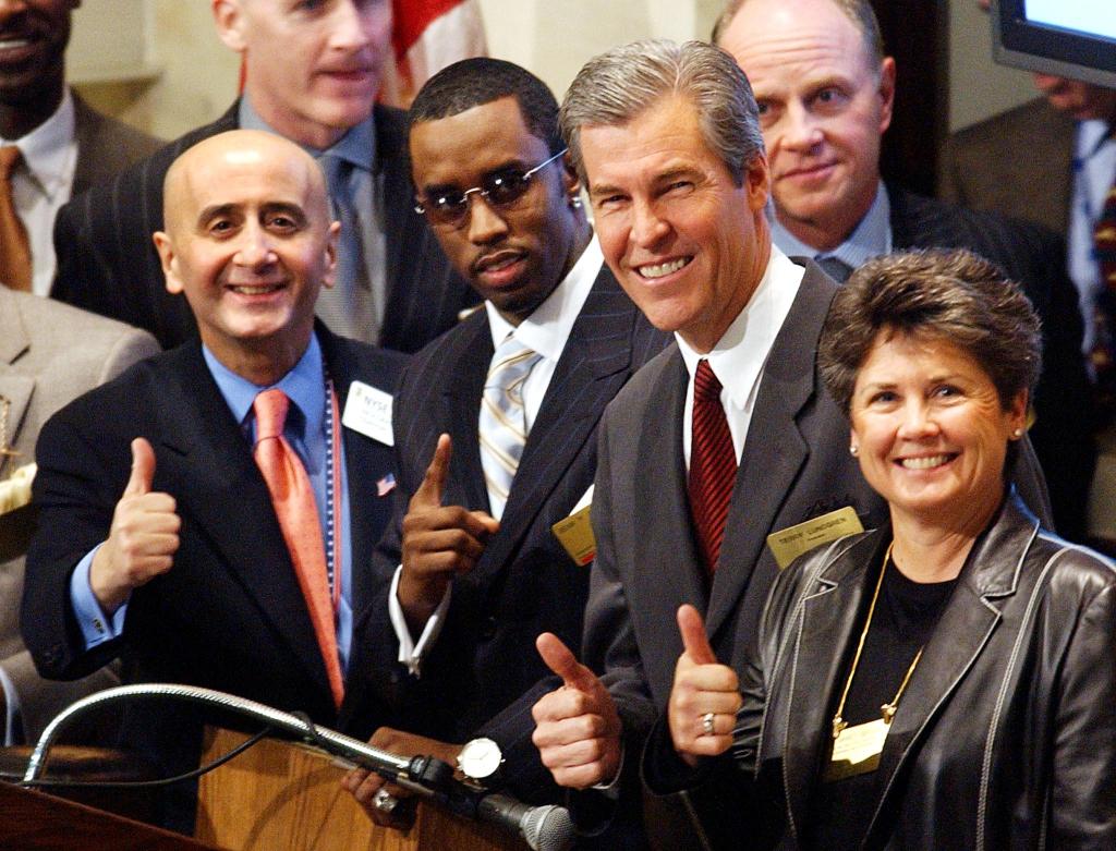 Sean 'P. Diddy' Combs, Richard Grasso, Terry Lundgren, and Janet Grove flashing a thumbs-up at the New York Stock Exchange in celebration of Fashion Week 2002