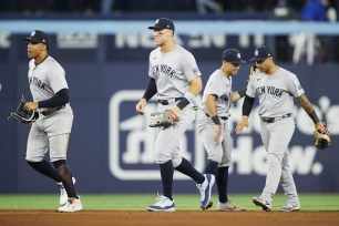 Juan Soto #22, Aaron Judge #99, Gleyber Torres #25, and Anthony Volpe #11 of the New York Yankees celebrate in the outfield after their MLB game against the Toronto Blue Jays at Rogers Centre on April 17, 2024 in Toronto, Canada.