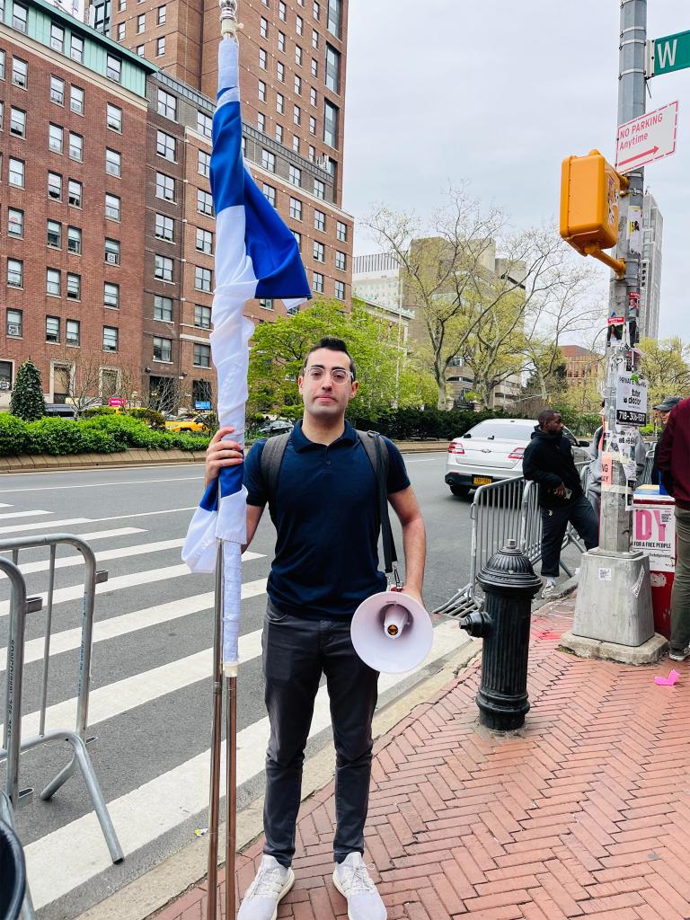 Jonny Lederer holding a flag and megaphone outside Columbia University on May 17, 1924