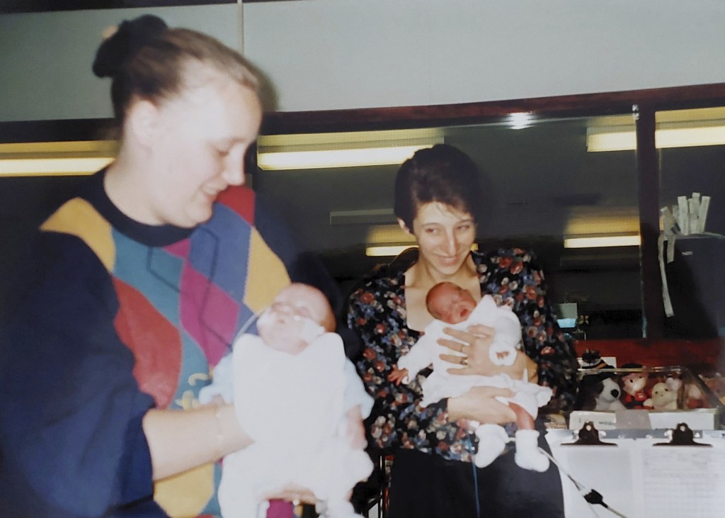 Jack Richardson and Bronwyn Tacey as babies together being held by their young mothers
