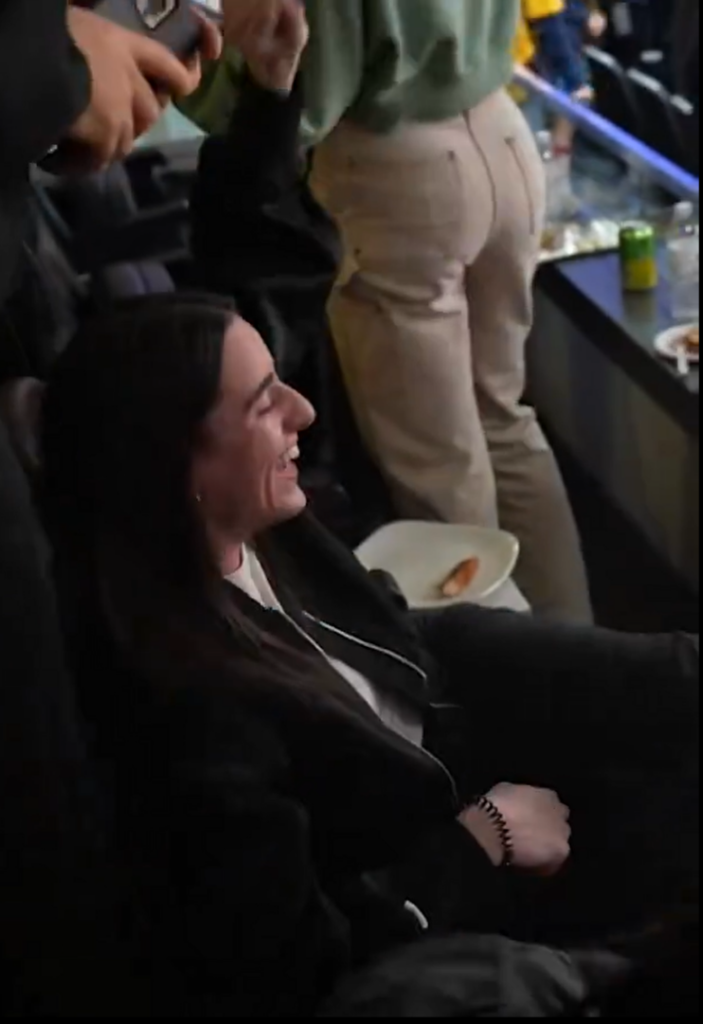 Caitlin Clark laughs after signing a fan's ultrasound picture at the Pacers-Bucks game on Friday night.