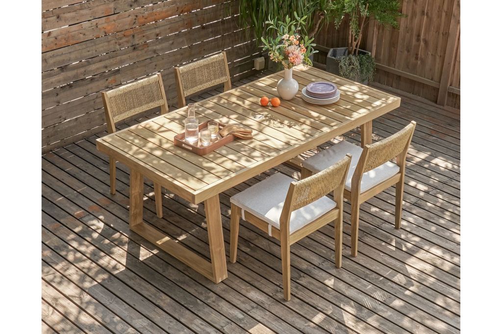 A table and chairs set up for outdoor dining on a deck