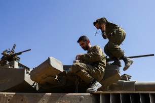 Israeli soldiers conduct some maintenance work on a Merkava tank near the Israel-Gaza border.