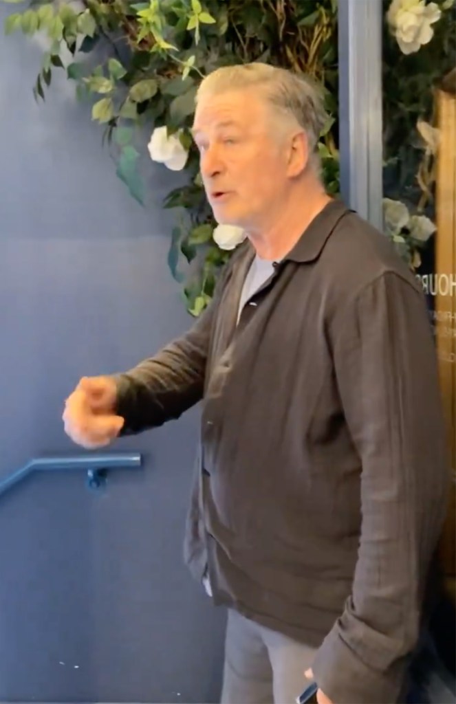 Alec Baldwin inside the coffee shop as the protester speaks to him