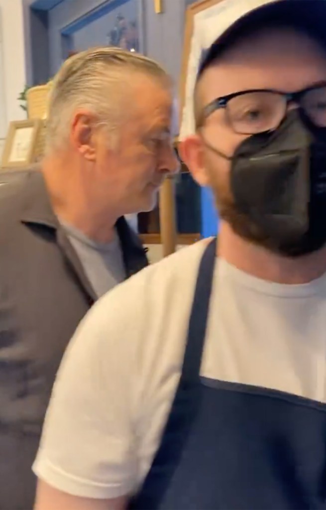 Alec Baldwin inside the coffee shop as the protester speaks to him