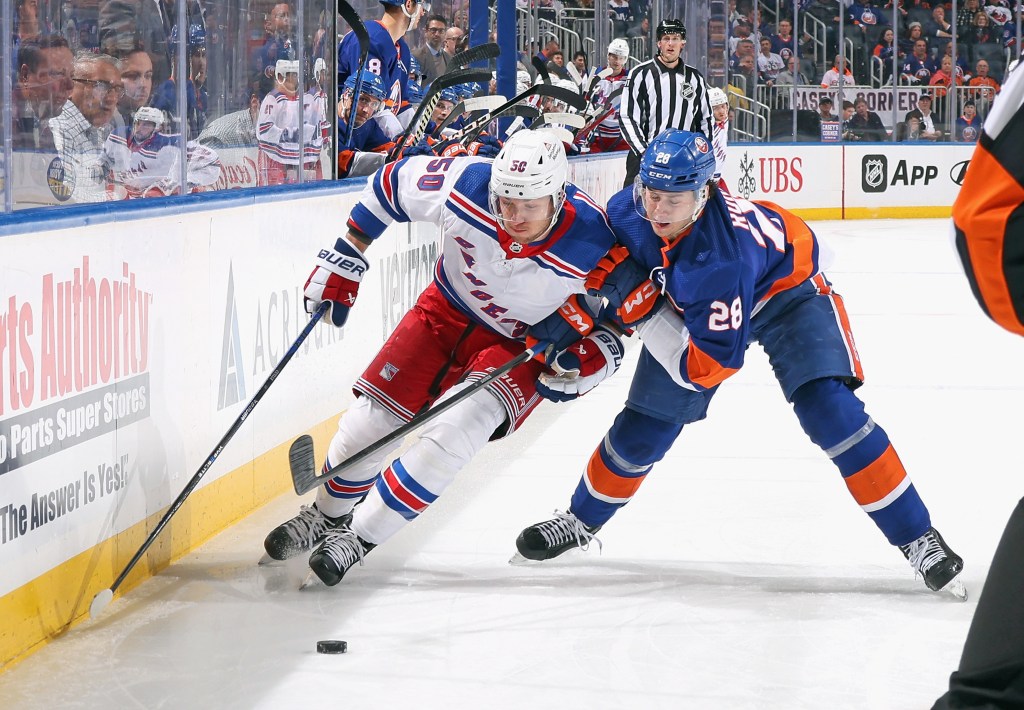 Alexander Romanov #28 of the New York Islanders checks Will Cuylle #50 of the New York Rangers