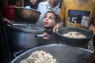Displaced Palestinians are collecting food donated by a charity before an iftar meal, the breaking of the fast, before the end of the Muslim holy fasting month of Ramadan.