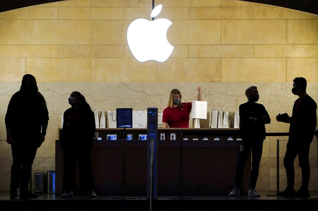 Apple employees working behind a counter at the Apple Store in Grand Central Terminal, New York City