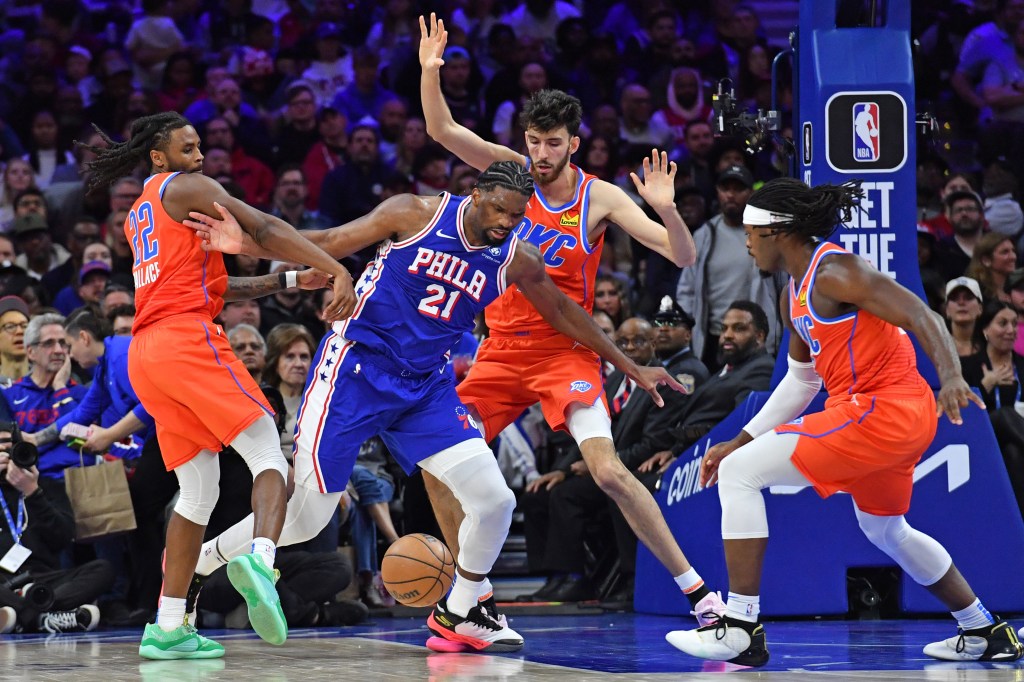  76ers center Joel Embiid (21) battles for the ball with Oklahoma City Thunder guard Cason Wallace (22), forward Chet Holmgren (7) and guard Luguentz Dort.