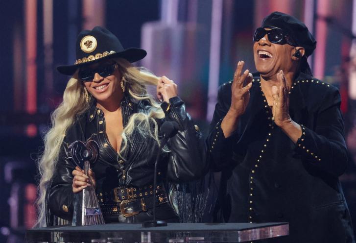 Beyonce and Stevie Wonder in black outfits, reacting to her receiving the Innovator award at 2024 iHeartRadio Music Awards in Los Angeles, California.