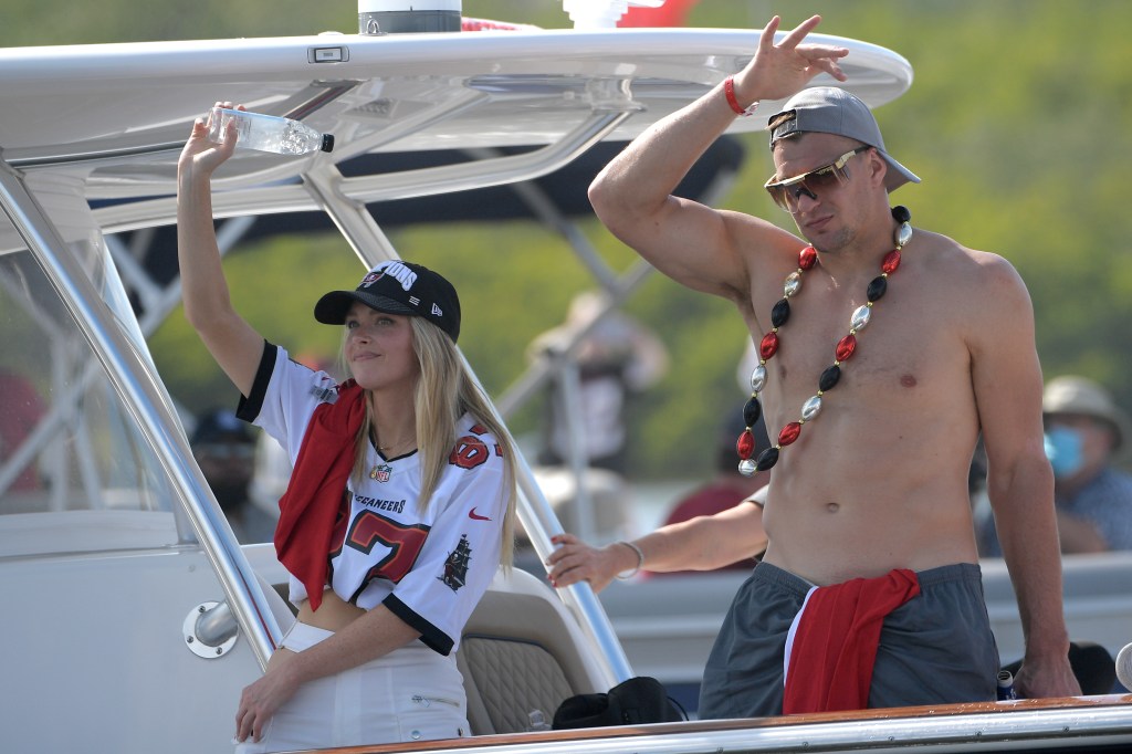 Tampa Bay Buccaneers tight end Rob Gronkowski, right, and Camille Kostek wave from a boat during a celebration of their Super Bowl 55 victory over the Kansas City Chiefs with a boat parade,  Feb. 10, 2021, in Tampa, Fla. 