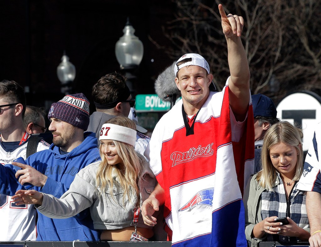 New England Patriots' Rob Gronkowski, center, celebrates alongside Camille Kostek, third from left, as the Patriots parade through downtown Boston, Tuesday, Feb. 5, 2019, to celebrate their win over the Los Angeles Rams in Super Bowl 53.