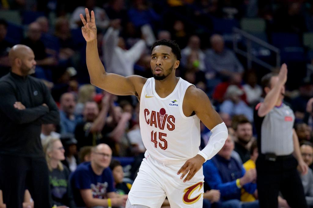 Cleveland Cavaliers guard Donovan Mitchell (45) in white uniform celebrating a three point basket during an NBA game against the New Orleans Pelicans