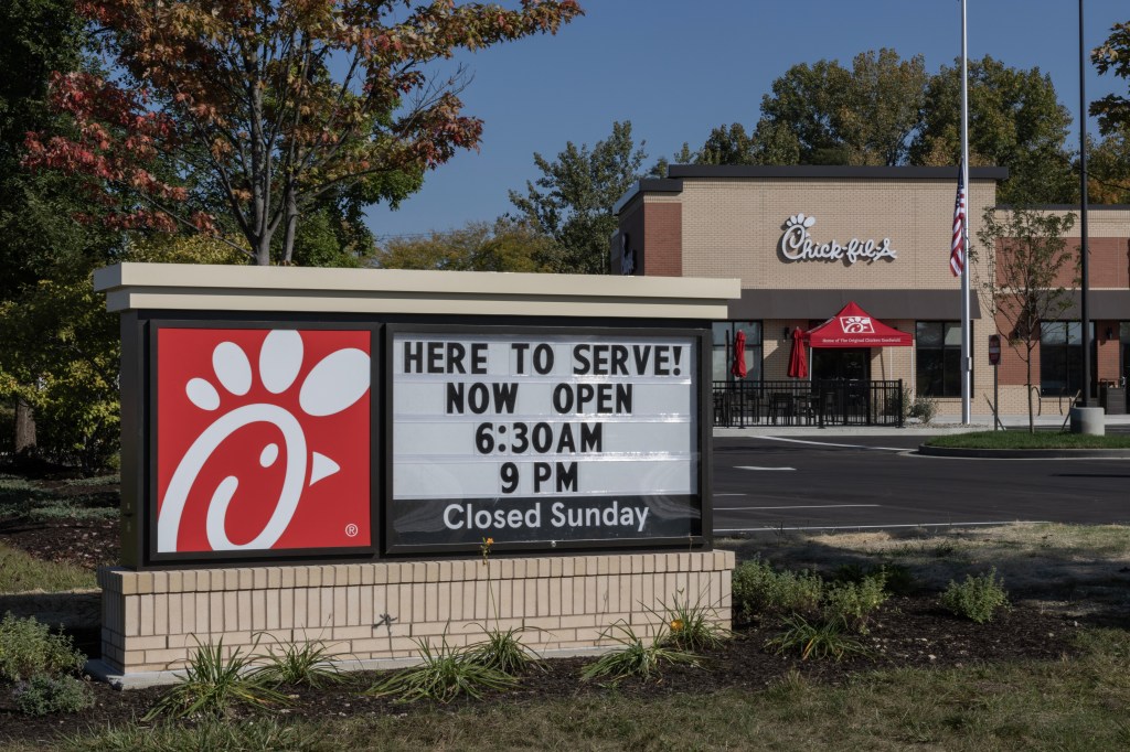 Chick-fil-A chicken restaurant sign on a brick wall in Carmel, dated October 1, 2023