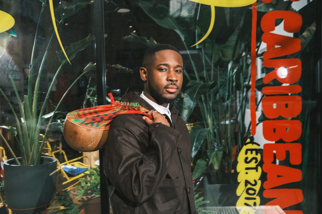 CJ Robinson posing for a portrait with a bag slung over his shoulder