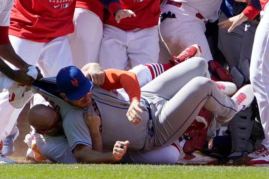 New York Mets' Pete Alonso is taken to the ground by St. Louis Cardinals first base coach Stubby Clapp, rear, as benches clear during a scuffle in the eighth inning of a baseball game Wednesday, April 27, 2022, in St. Louis. Clapp was ejected from the game. 