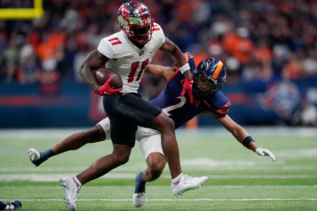 Western Kentucky wide receiver Malachi Corley running with the football against UTSA cornerback Corey Mayfield Jr. during a college football game