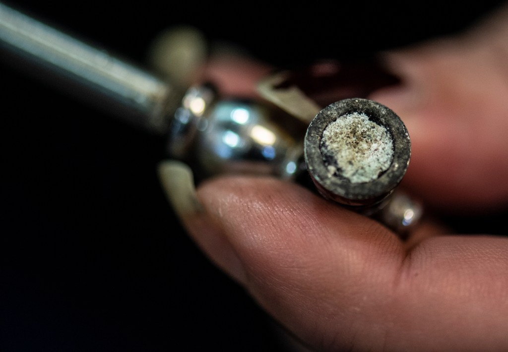 Woman preparing a crack pipe in a controlled drug consumption room in Frankfurt, Hessen