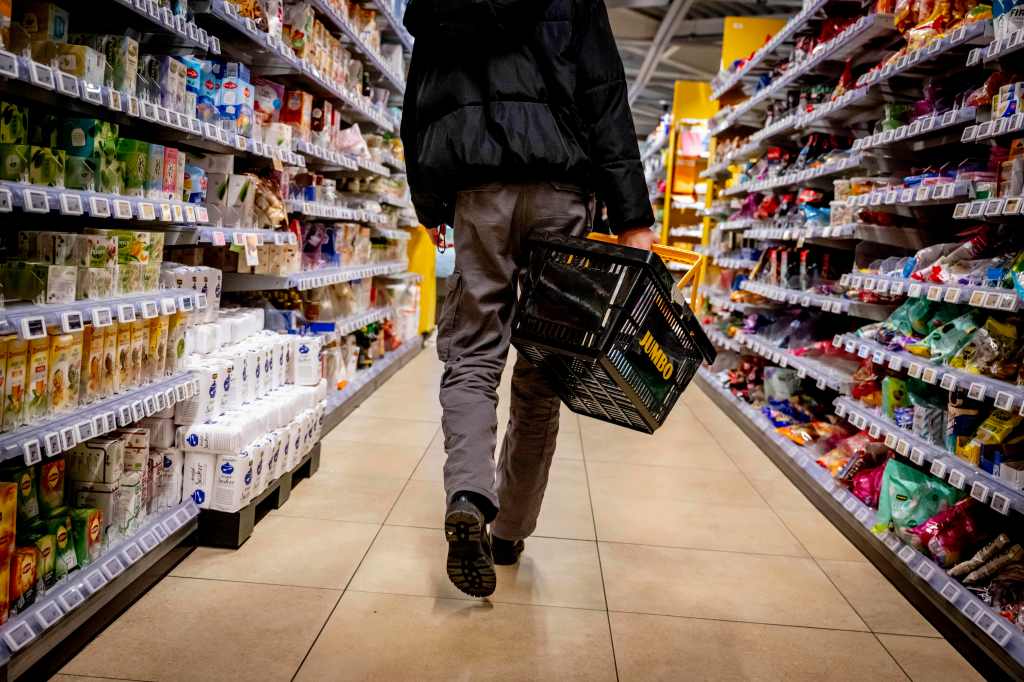 A customer shopping in a Jumbo supermarket in Rotterdam, Netherlands while holding a basket