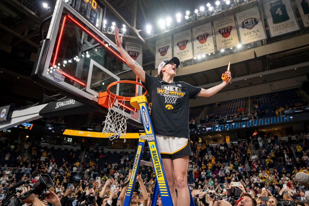 Hawkeyes guard Caitlin Clark (22) cuts down the net after beating LSU in the Elite 8 round