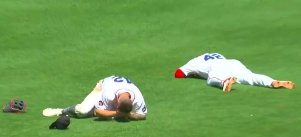 Tyler O'Neill (l.) and Rafael Devers (r.) on the ground after they banged heads.