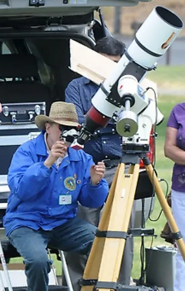 Man looking into the sky through an elaborate telescope