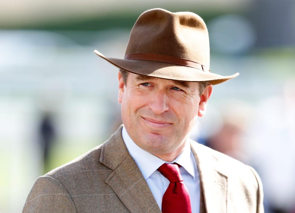 Peter Phillips, eldest grandchild of the late Queen Elizabeth II, wearing a suit and hat at Gold Cup Day, Cheltenham Festival in Cheltenham, England.