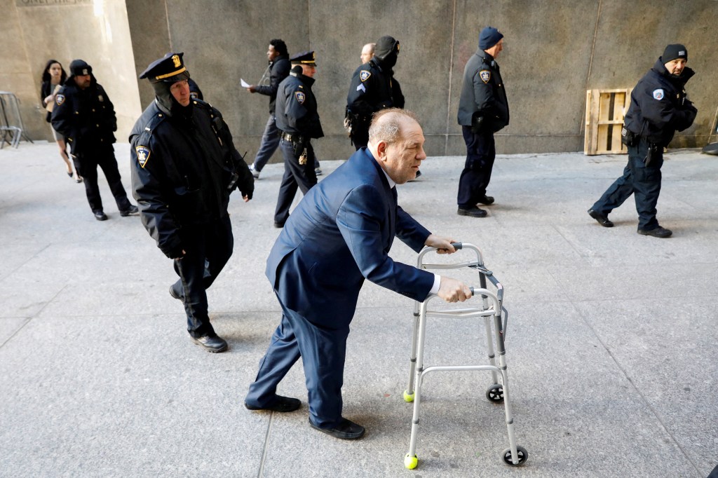 Harvey Weinstein walks with the aid of a walker.