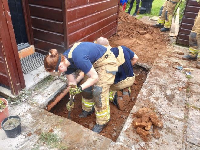 The Swansea West crew firefighters digging up the patio to save a dog named Jock.