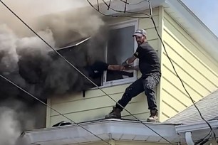 Oscar Rivera, 48, was seen in a video obtained by Storyful standing on a roof and reaching into an attic window of the Minersville home.