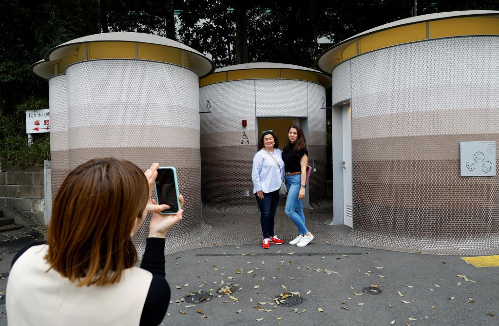 Foreign tourists get their photos taken in front of a public toilet which was redesigned as part of a project to transform public toilets into restrooms that can be used comfortably by everyone.