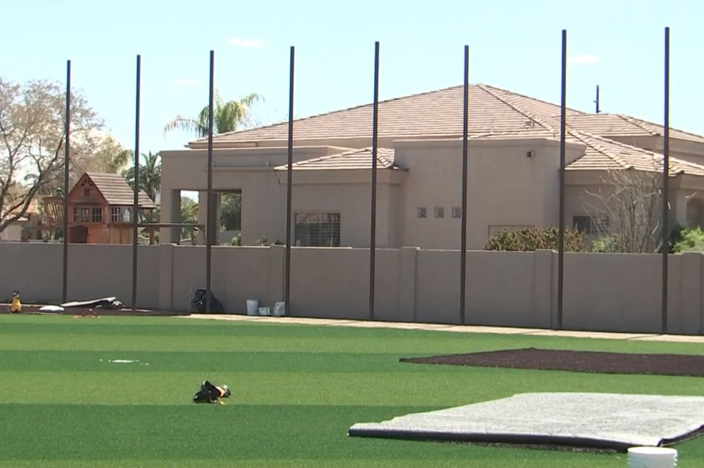 The upset neighbor only learned what was being built behind her home when she saw 20-foot poles being drilled into the ground.