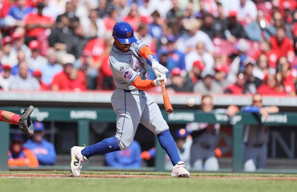 Francisco Lindor hits a double in the Mets' win over the Reds on Sunday.