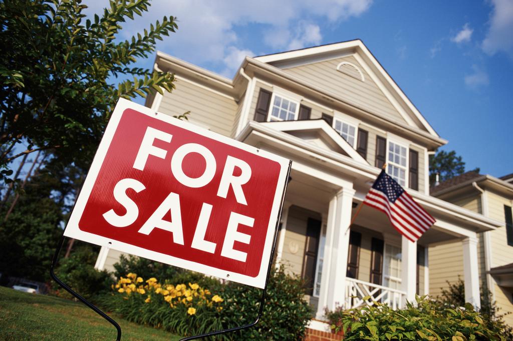 Low angle view of a house with an American flag and 'for sale' sign in Georgia, USA