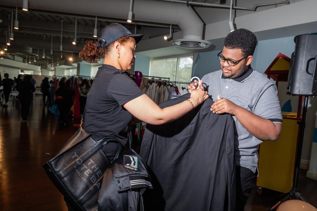 Griselda Ramirez helping her son, Israel Martinez, choose a suit at a prom clothing giveaway event by Operation Prom in New York