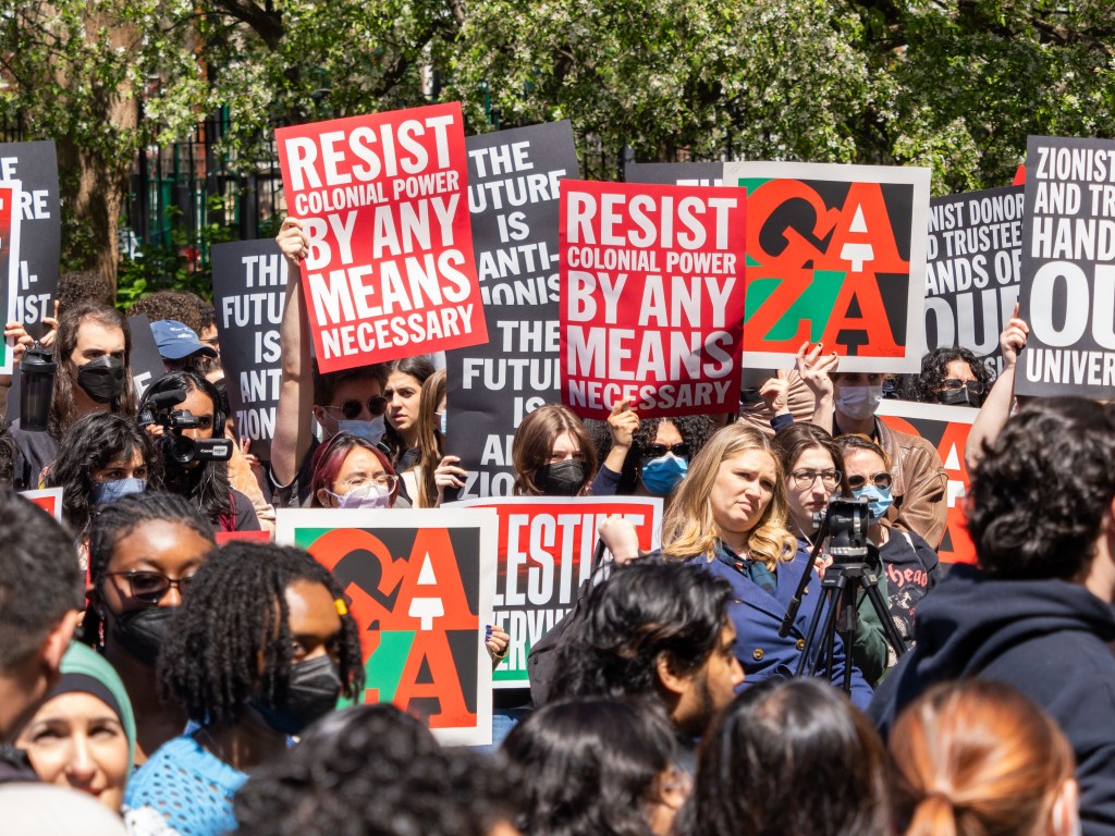 A group of NYU students, faculty and supporters hold signs to free Palestine during a rally held in Washington Square Park