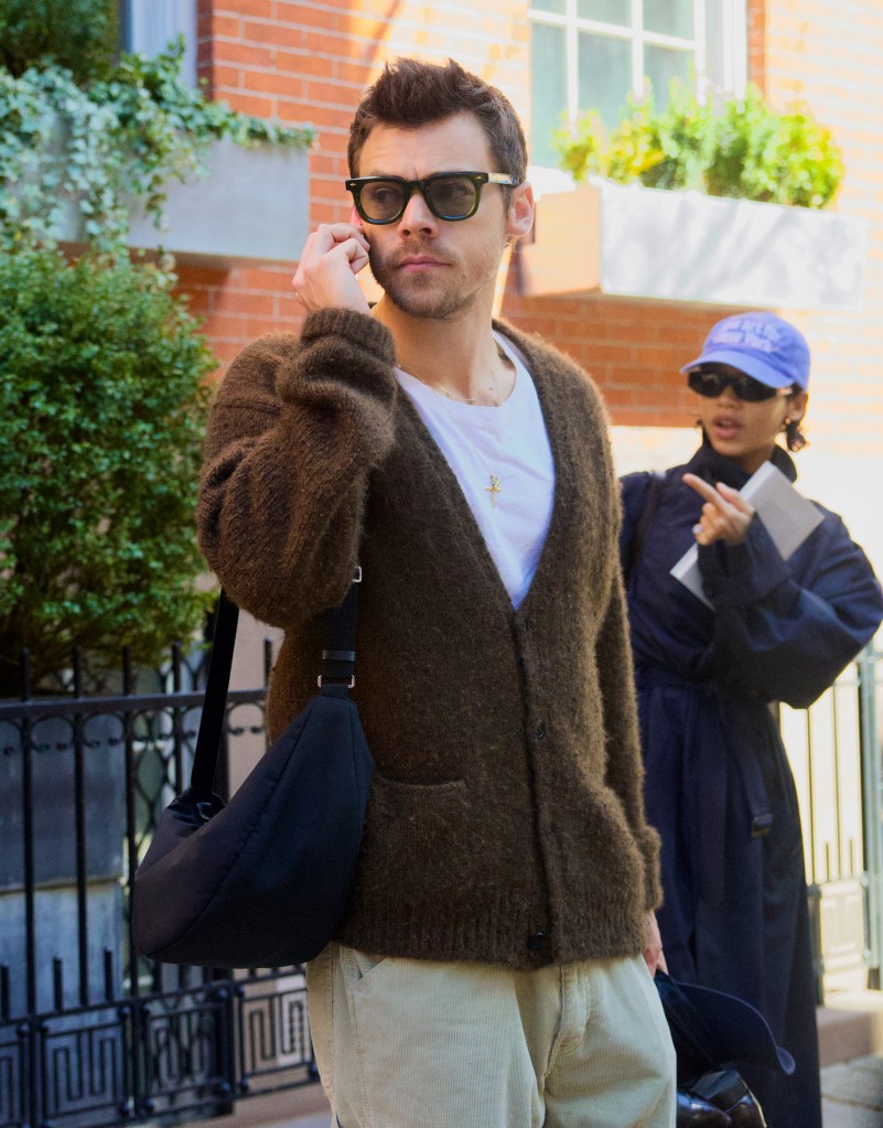Harry Styles in Jacques Marie Mage sunglasses, brown cashmere cardigan and tan corduroy trousers, conversing with girlfriend Taylor Russell in a navy trench coat, jeans and brown loafers, as they exit a Brooklyn Brownstone.