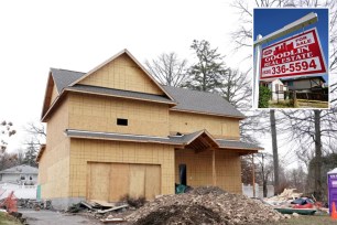 Home for sale sign and home under construction