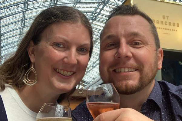 A happy couple, Charlotte Robertson and Glen, holding wine glasses, celebrating their marriage