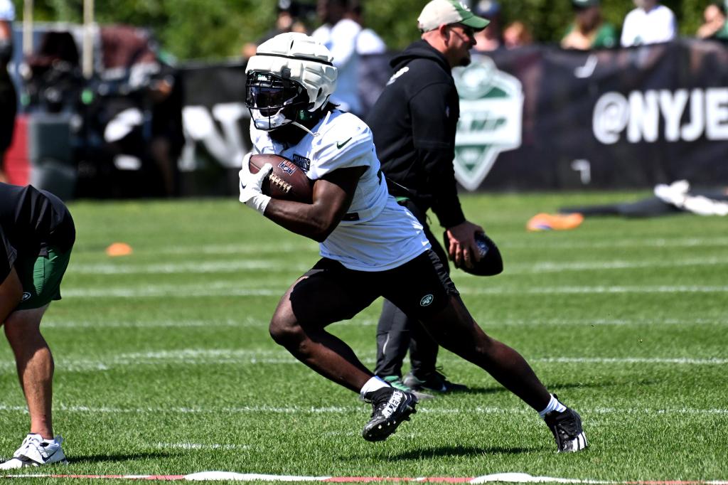 Jets running back Michael Carter (32) runs the ball during practice