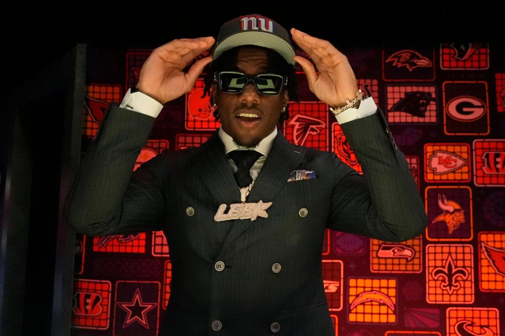 LSU wide receiver Malik Nabers puts on a hat after being chosen by the New York Giants with the sixth overall pick.