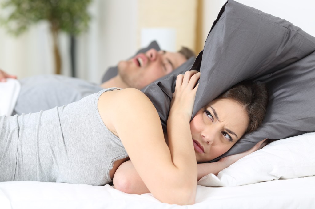 Woman with pillow over her head